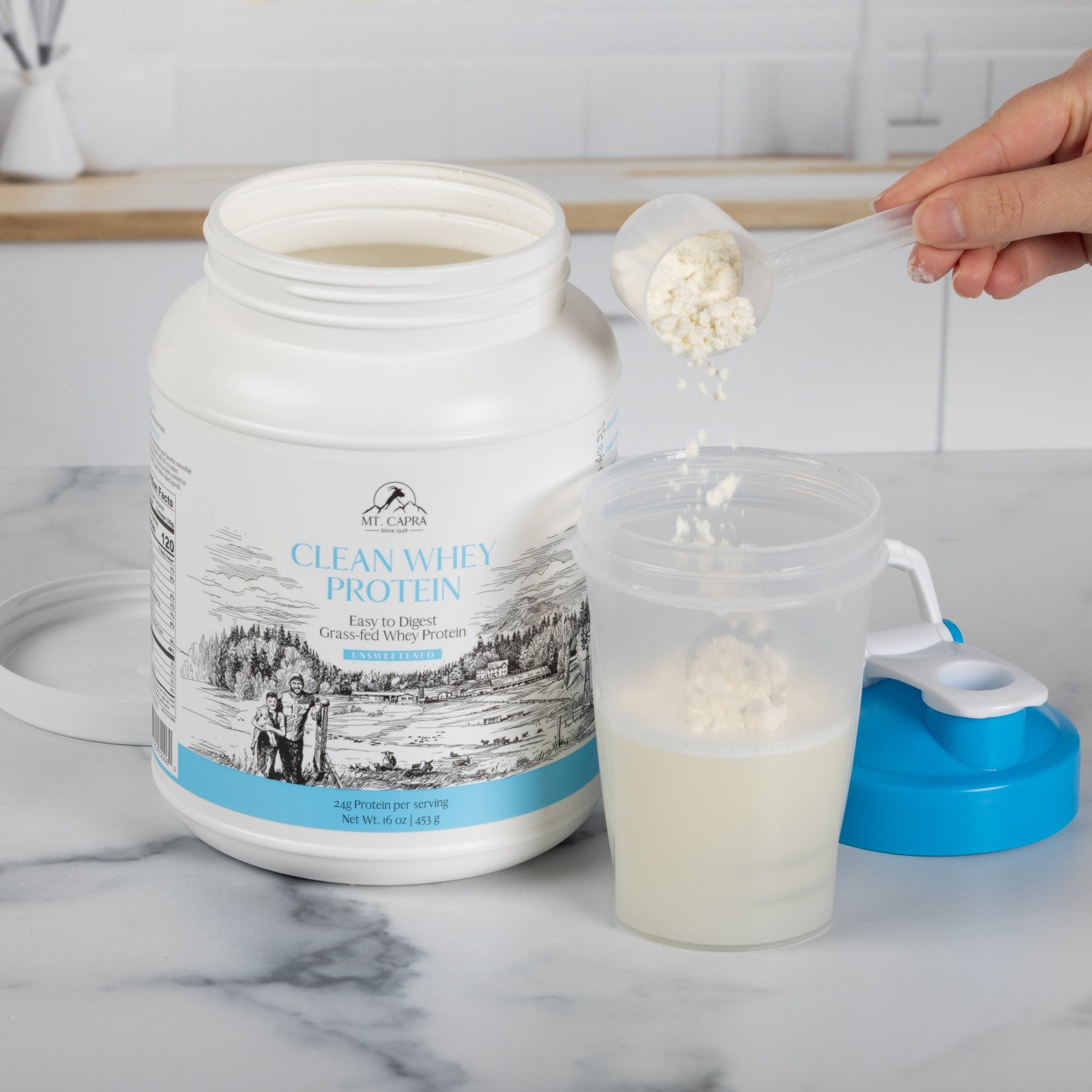 Person pouring whey protein into a shaker cup