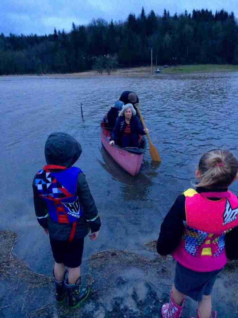 Ann crosses the flooded pasture in a canoe